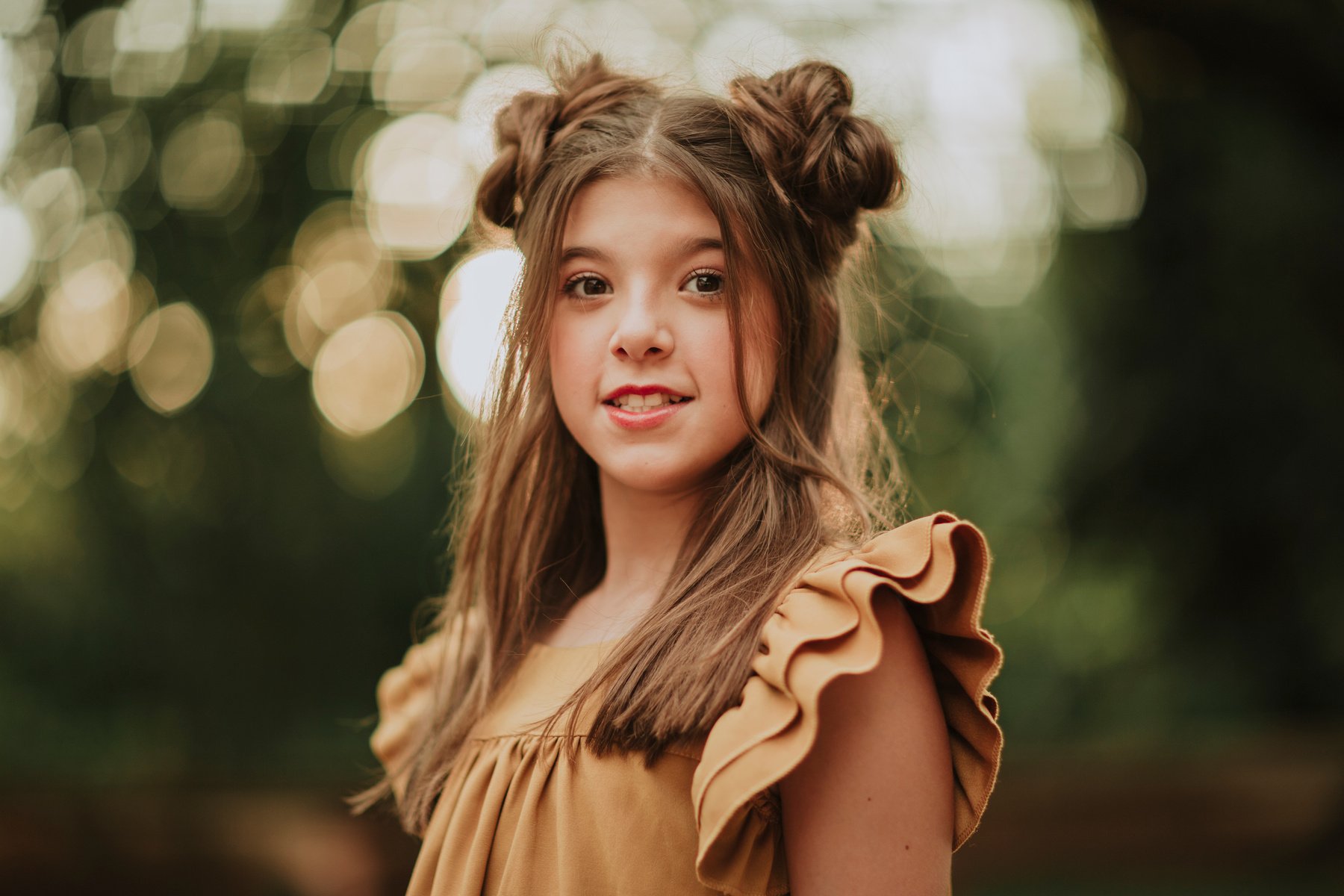 Stylish teen girl smiling at camera in green park